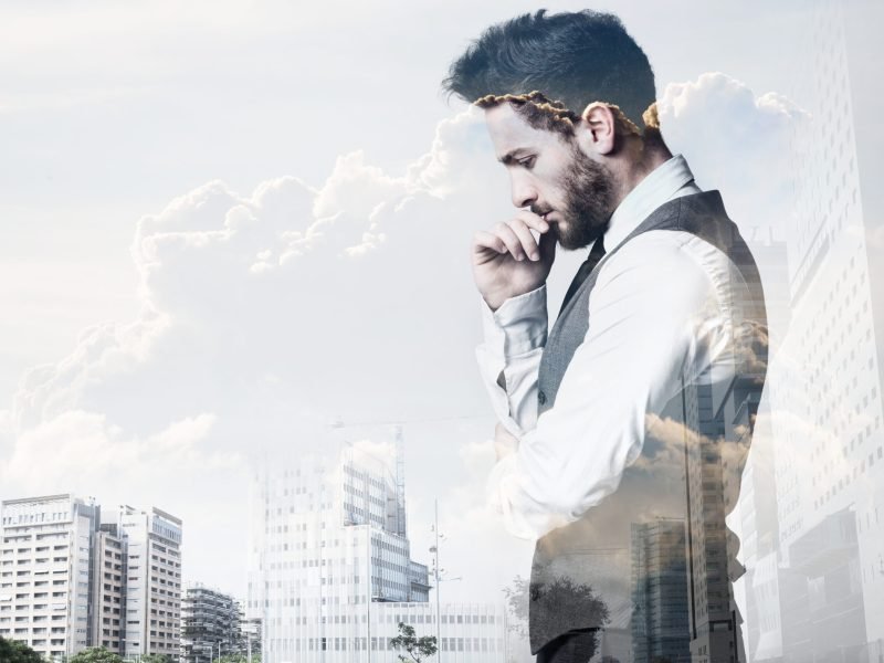 Portrait of double exposure of young businessman and city.